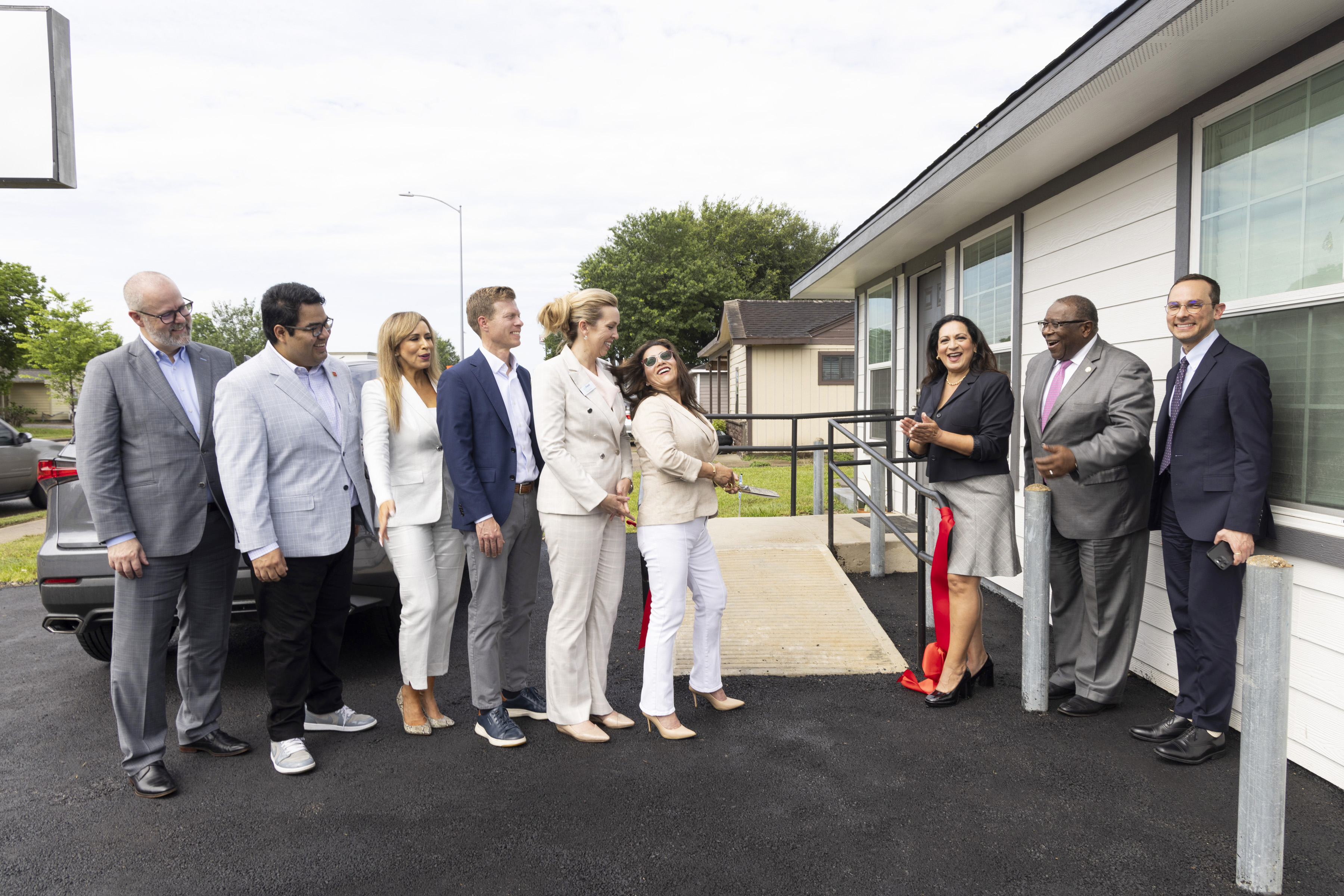 Sandra Lopez, owner of City-Wide General Contractors, laughs with company while unveiling her new property 
