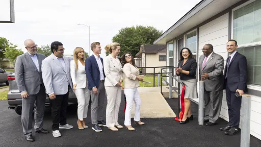 Sandra Lopez, owner of City-Wide General Contractors, laughs with company while unveiling her new property 