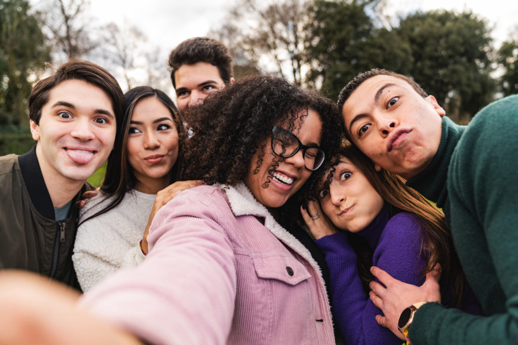 Pov view of a multi ethnic group of six friends taking a selfie together while they are making faces. They are looking at camera and making faces.